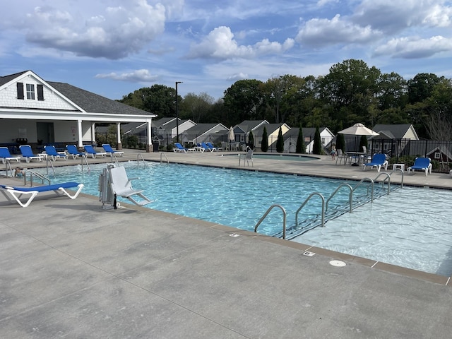 pool with a patio and fence