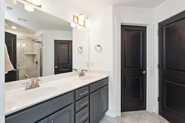 bathroom featuring visible vents, a sink, a shower stall, and double vanity