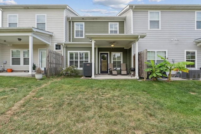 rear view of house featuring central air condition unit, a patio area, fence, and a lawn