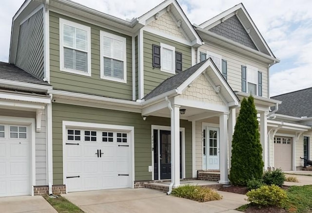 craftsman-style house with concrete driveway, roof with shingles, and an attached garage