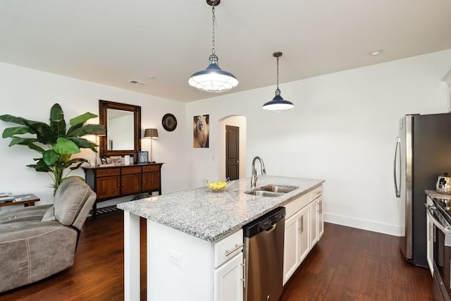 kitchen featuring dark wood-type flooring, appliances with stainless steel finishes, arched walkways, and a sink