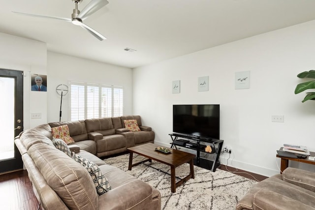 living room featuring visible vents, ceiling fan, baseboards, and wood finished floors