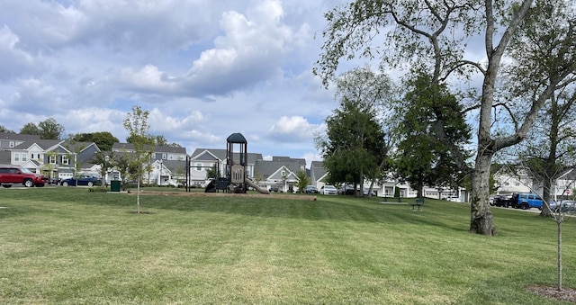 surrounding community featuring a residential view, a lawn, and playground community