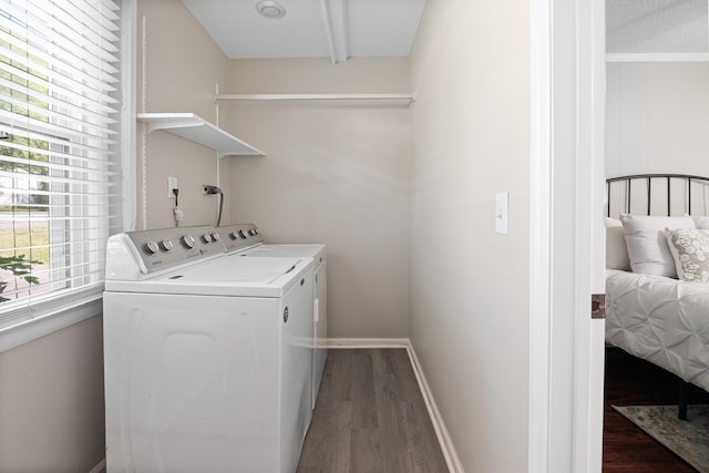 laundry area with laundry area, baseboards, separate washer and dryer, and wood finished floors