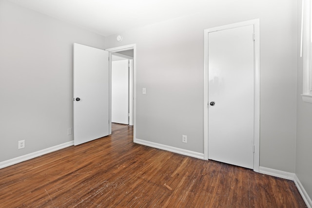 unfurnished bedroom with wood-type flooring and baseboards