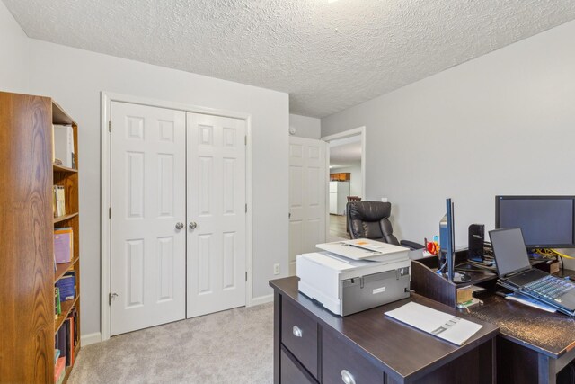 office space featuring light colored carpet, a textured ceiling, and baseboards