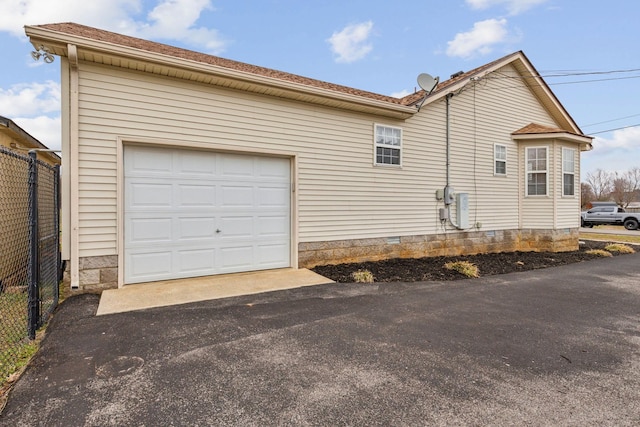 view of property exterior featuring a garage, crawl space, fence, and driveway