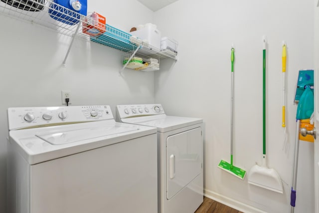 laundry room with laundry area, separate washer and dryer, and dark wood-style flooring