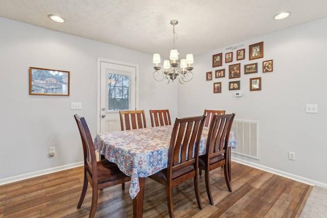 dining area with recessed lighting, visible vents, hardwood / wood-style floors, a chandelier, and baseboards