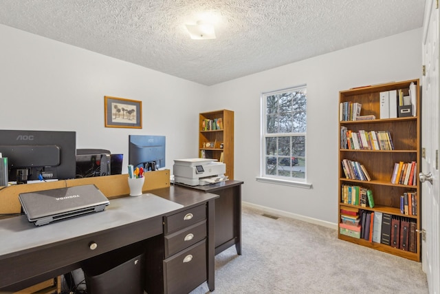 office featuring baseboards, a textured ceiling, visible vents, and light colored carpet