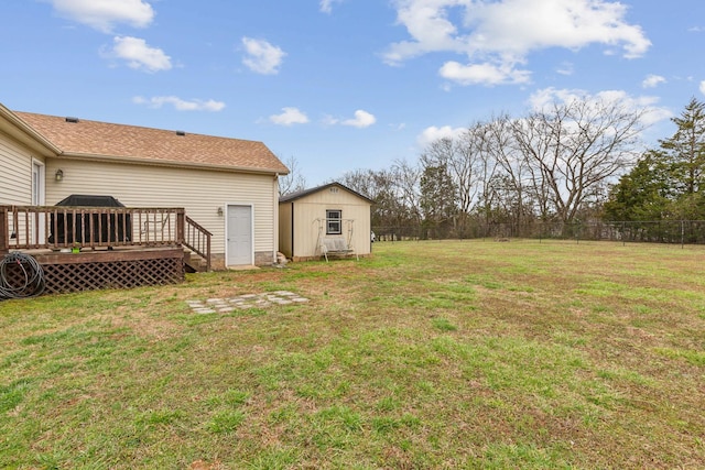 view of yard with a shed, fence, an outdoor structure, and a wooden deck