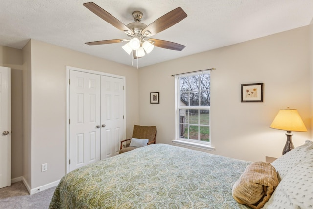 bedroom featuring carpet floors, a closet, ceiling fan, a textured ceiling, and baseboards