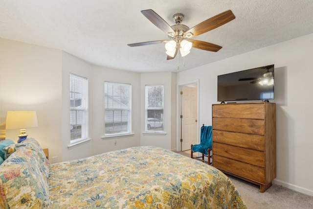 bedroom with carpet floors, multiple windows, baseboards, and a textured ceiling