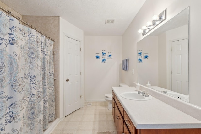 full bathroom featuring visible vents, vanity, toilet, and a textured ceiling