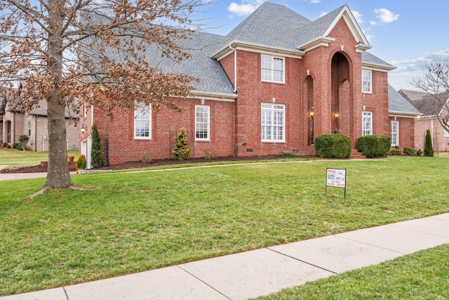 view of front of home featuring crawl space, brick siding, roof with shingles, and a front lawn