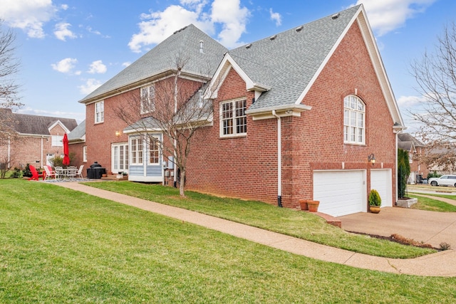 exterior space with a lawn, entry steps, concrete driveway, an attached garage, and brick siding