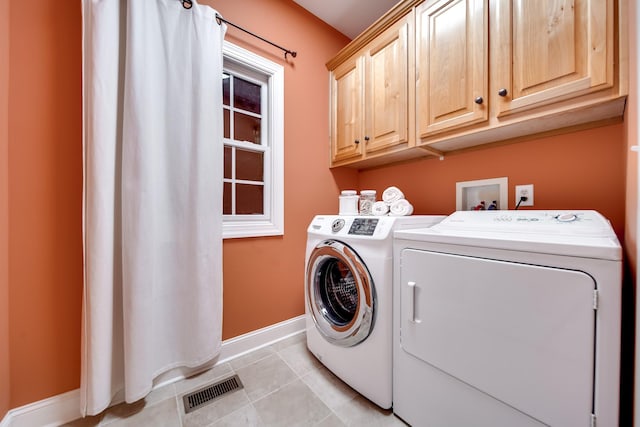 laundry area featuring independent washer and dryer, visible vents, light tile patterned flooring, baseboards, and cabinet space