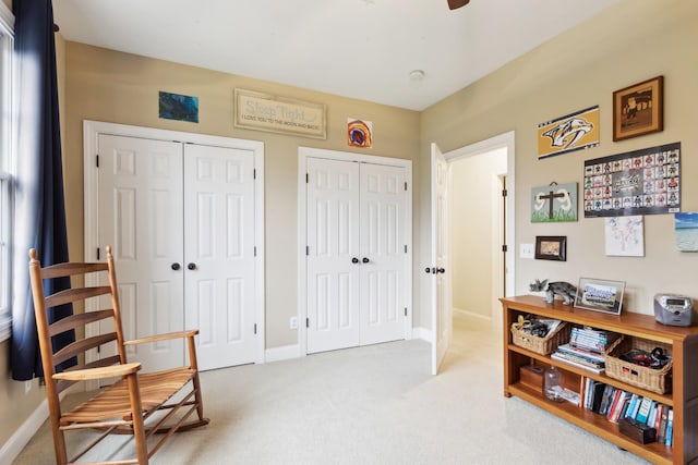 living area featuring ceiling fan, carpet flooring, and baseboards