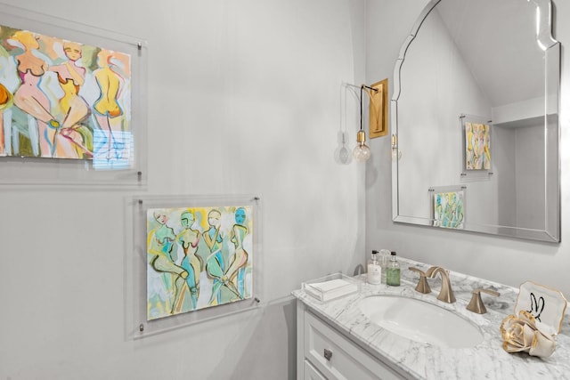 bathroom featuring lofted ceiling and vanity