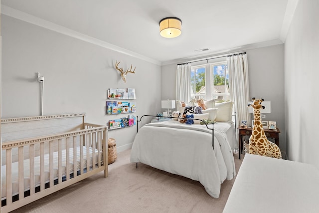 carpeted bedroom with ornamental molding and baseboards