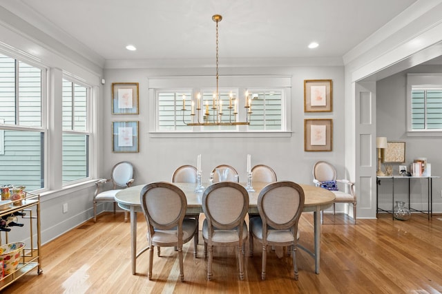 dining area featuring a chandelier, crown molding, and wood finished floors