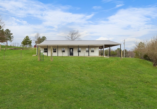 exterior space with metal roof, a carport, and a front lawn