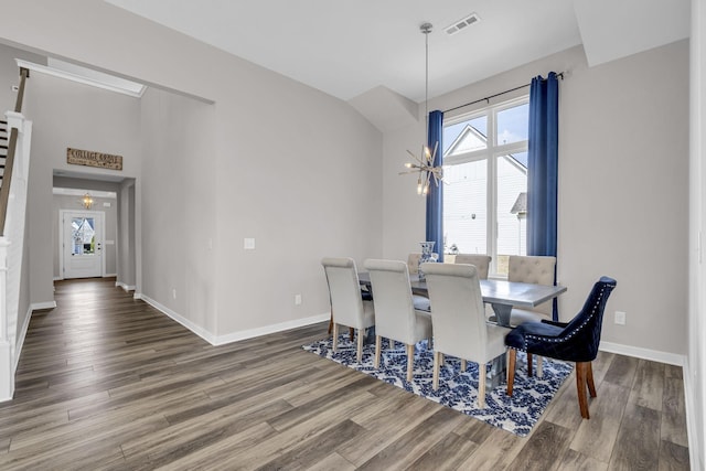 dining room featuring a chandelier, plenty of natural light, wood finished floors, and baseboards