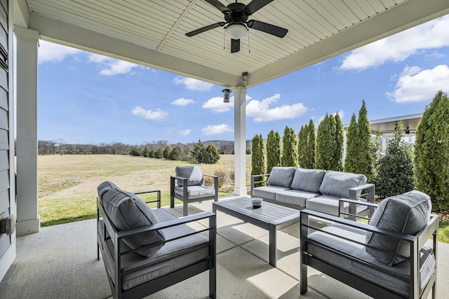 view of patio featuring a rural view, an outdoor living space, and a ceiling fan