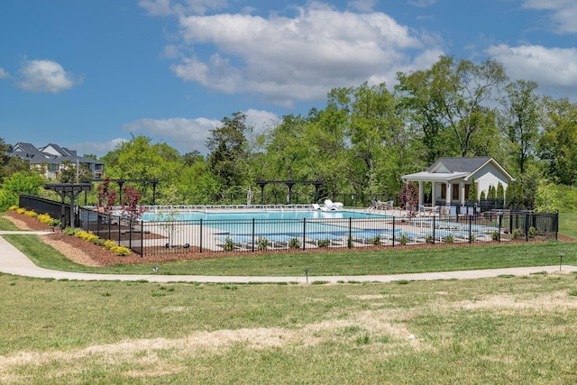 pool featuring fence and a yard