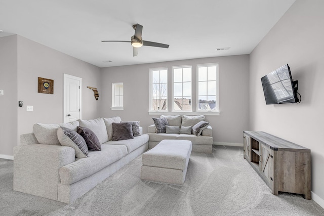 living area with baseboards, visible vents, and light colored carpet