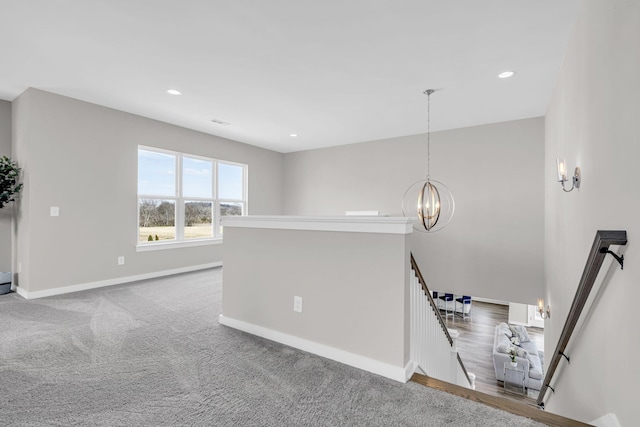 interior space with carpet floors, an inviting chandelier, baseboards, and recessed lighting