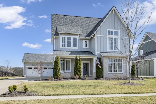 view of front of house with driveway, an attached garage, board and batten siding, and a front yard