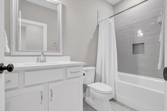 bathroom featuring marble finish floor, vanity, toilet, and shower / bathtub combination with curtain