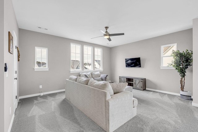 carpeted living room featuring baseboards, visible vents, and ceiling fan