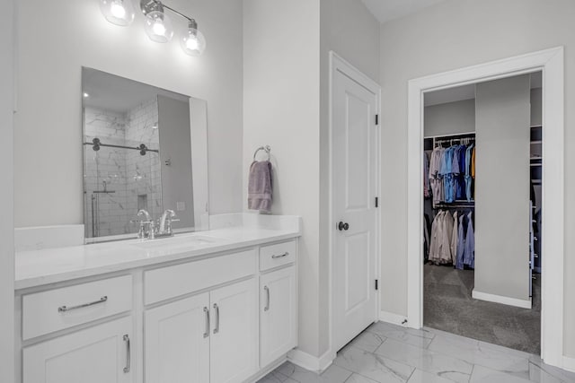 bathroom featuring vanity, baseboards, marble finish floor, a spacious closet, and a shower stall