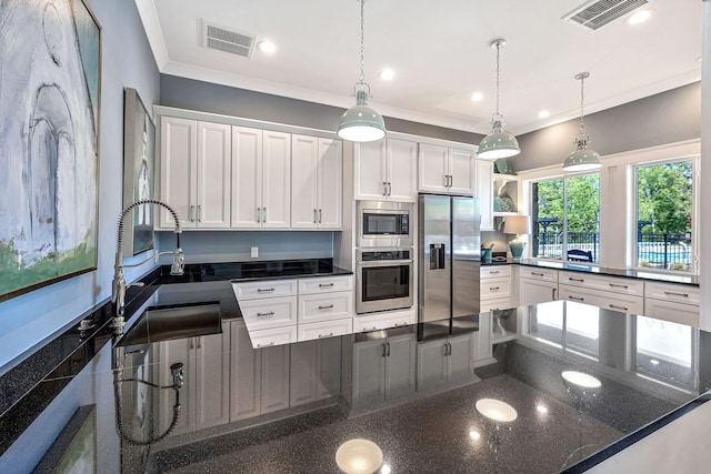 kitchen with a peninsula, appliances with stainless steel finishes, a sink, and visible vents