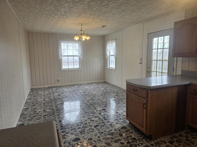 unfurnished dining area featuring a chandelier, plenty of natural light, and wallpapered walls