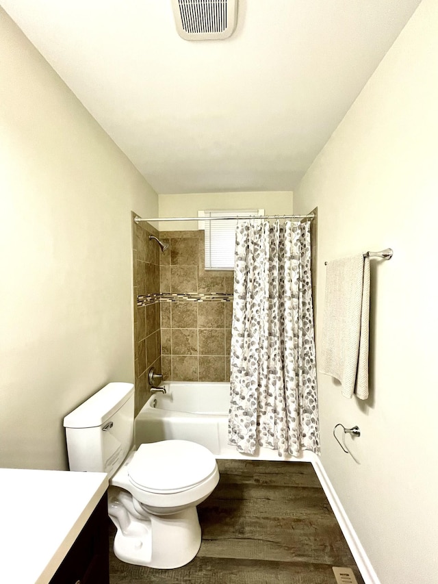 bathroom featuring toilet, wood finished floors, vanity, visible vents, and shower / bathtub combination with curtain