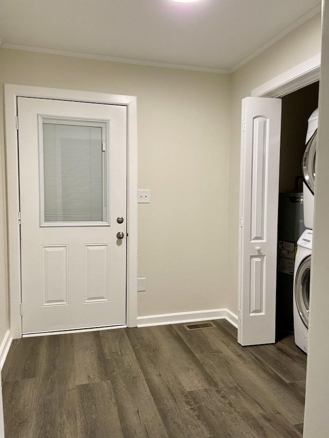 interior space featuring stacked washing maching and dryer, crown molding, laundry area, and dark wood-type flooring