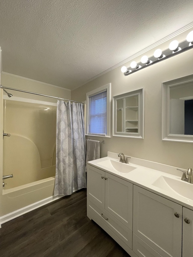 full bathroom with shower / bath combo, a sink, a textured ceiling, and wood finished floors