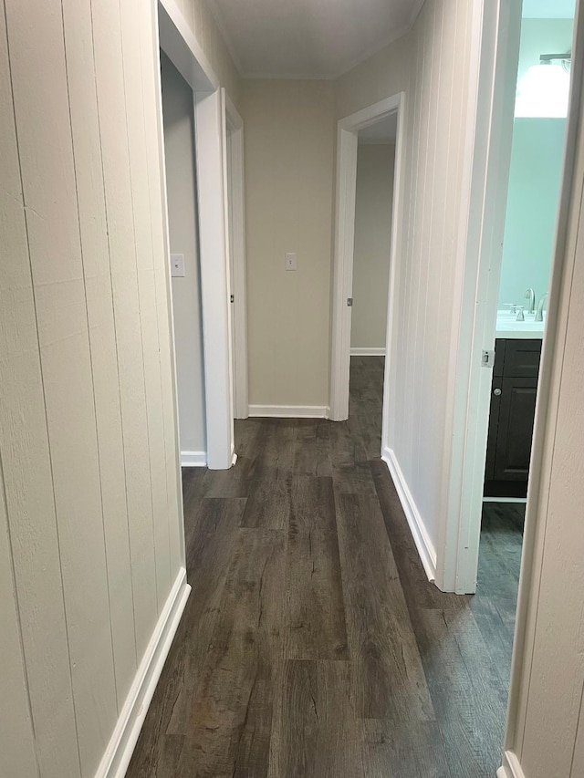 corridor with dark wood-style flooring and baseboards