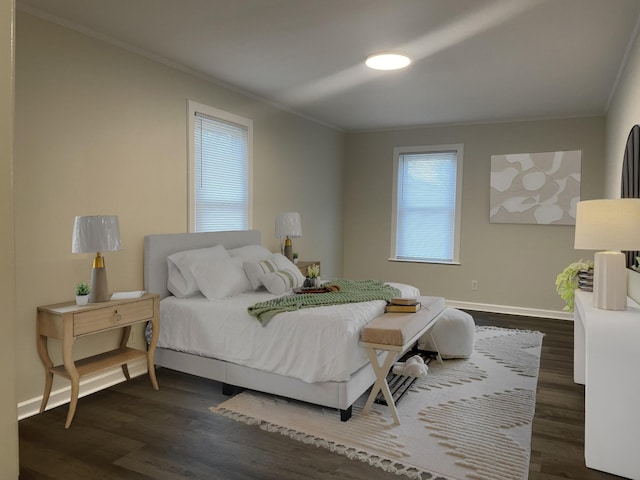 bedroom with baseboards, dark wood finished floors, and crown molding