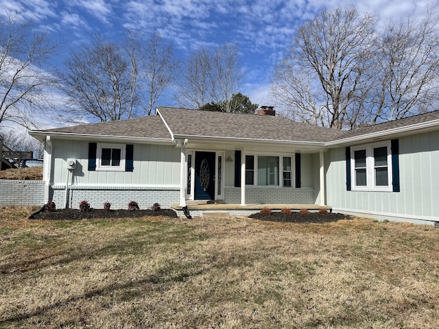 ranch-style home featuring brick siding, roof with shingles, a front lawn, board and batten siding, and a chimney