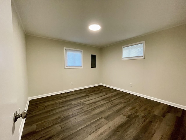 interior space featuring dark wood-style floors, visible vents, baseboards, and ornamental molding