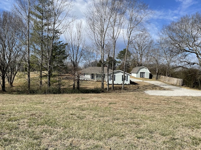 view of yard with driveway and fence