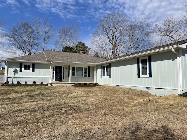 view of front of property with brick siding, a chimney, a shingled roof, a front yard, and crawl space