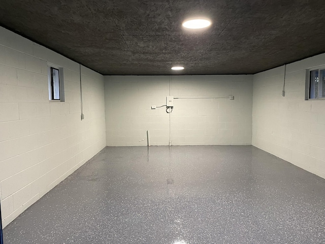 finished below grade area featuring a textured ceiling and concrete block wall