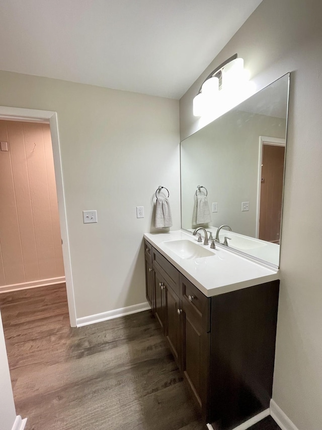 bathroom featuring vanity, baseboards, and wood finished floors