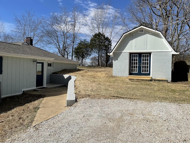 view of yard featuring entry steps, french doors, and an outdoor structure