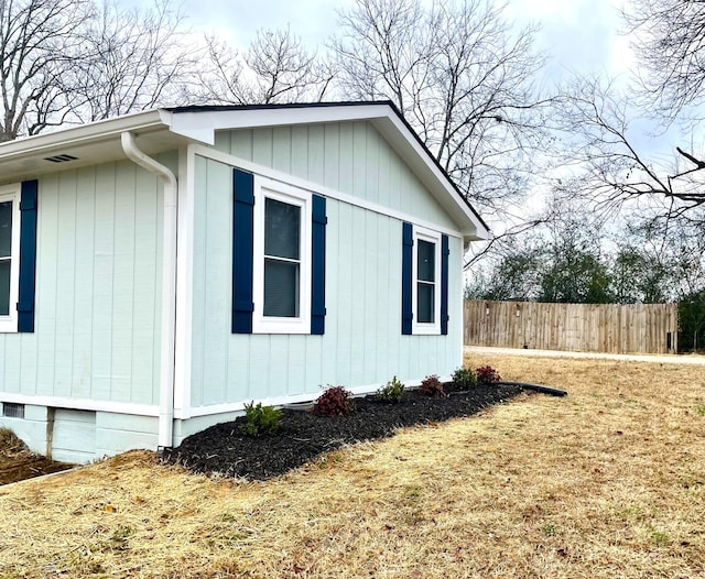 view of side of property with crawl space and fence